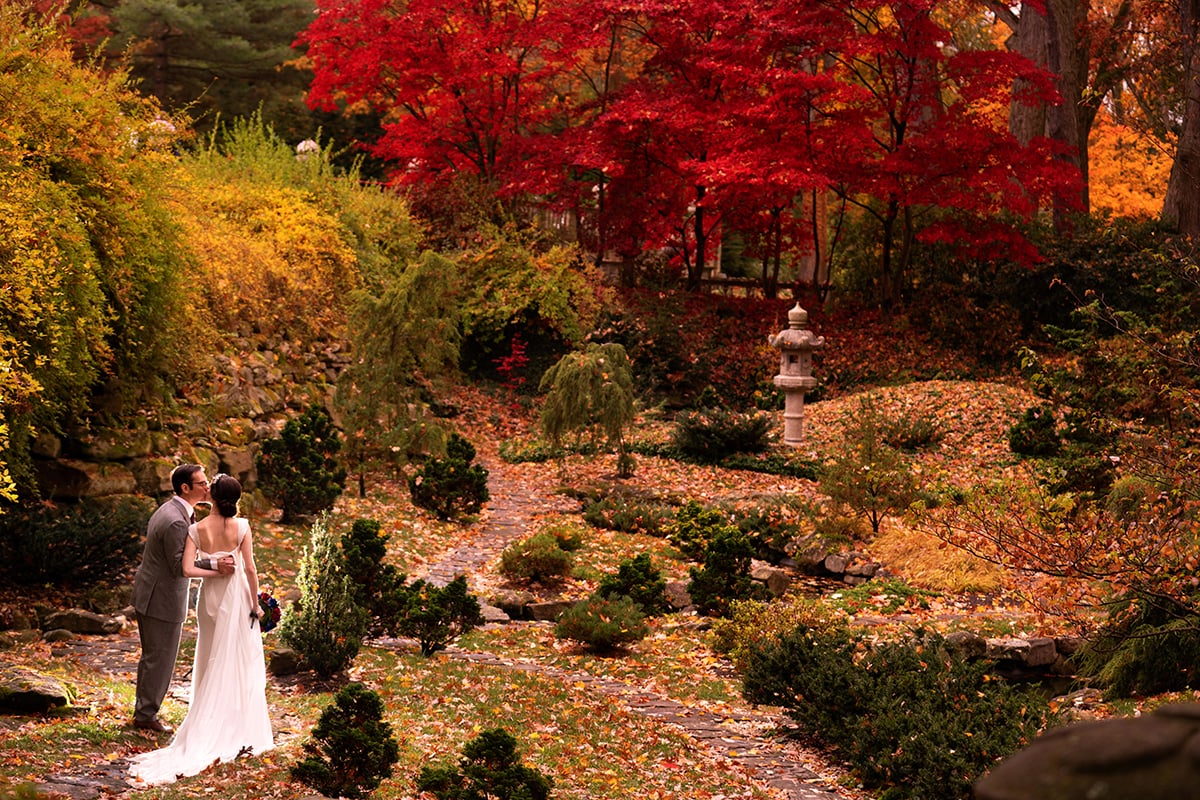 bride and groom kissing in Japanese Garden at Stan Hywet wedding