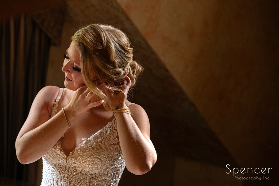 bride putting on earring at Landolls Mohican Castle