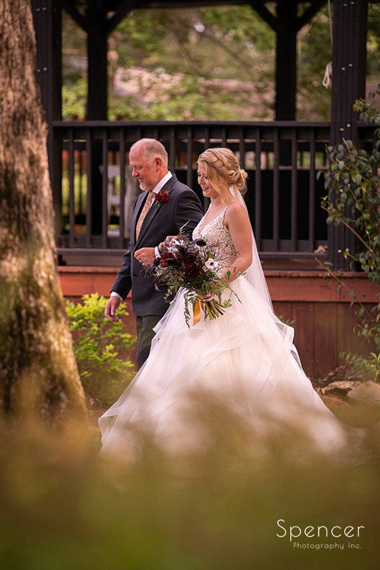 bride and father walking to wedding ceremony at Landolls