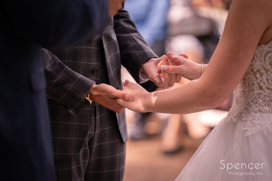 bride and groom holding hands during wedding at Landolls