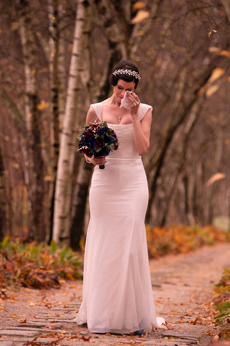 bride wiping her eyes in Birch Alley at Stan Hywet